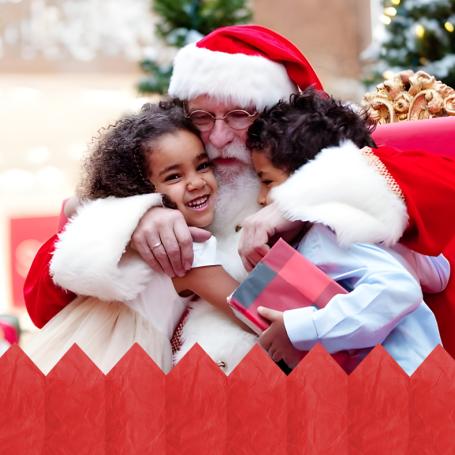 Santa hugging two kids