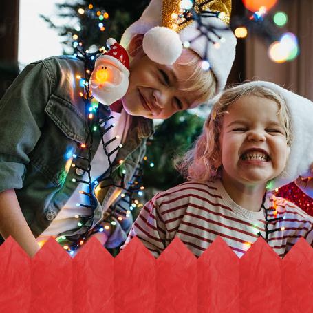 Kids smiling in front of a Christmas Tree