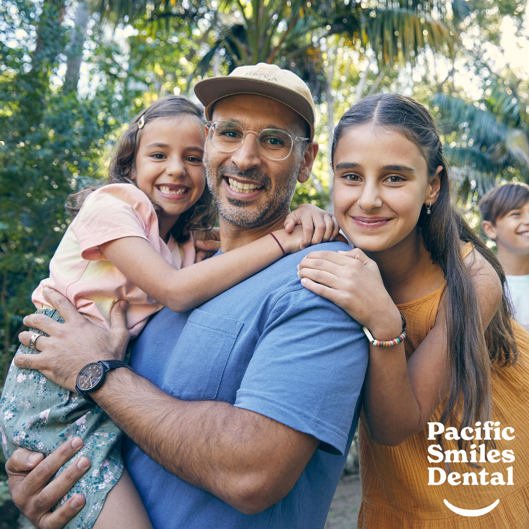 A family hugging. The Pacific Smiles Dental logo in the corner.