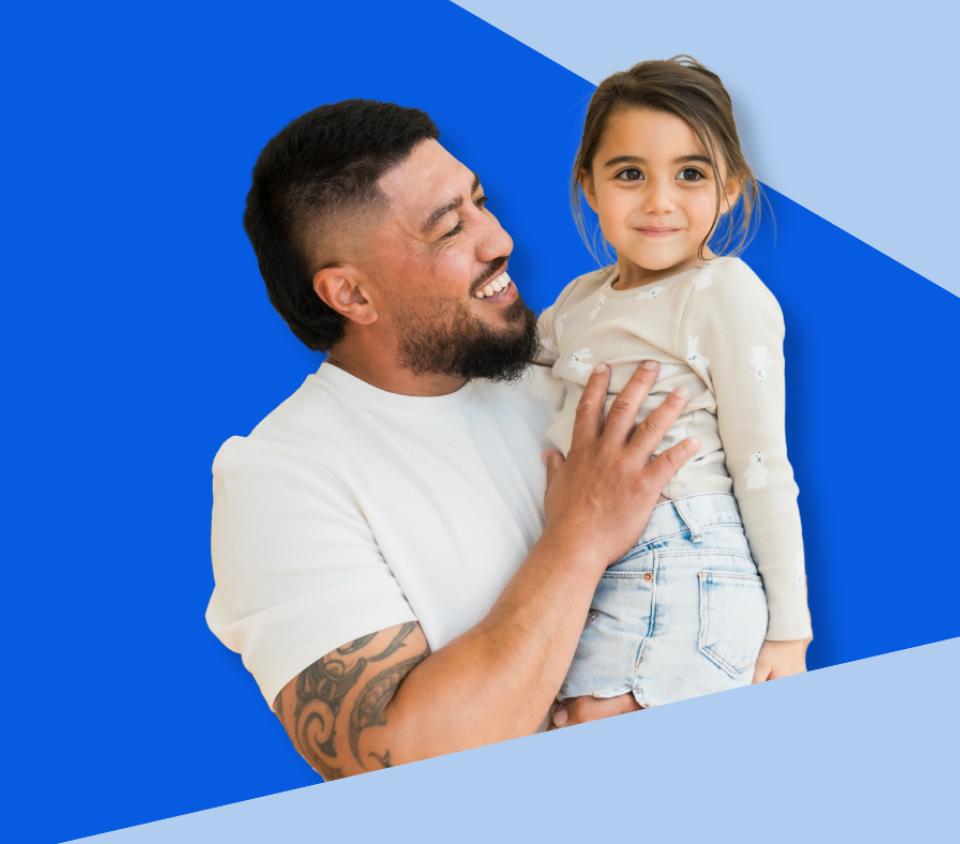 Man holding his little girl, looking on smiling. 